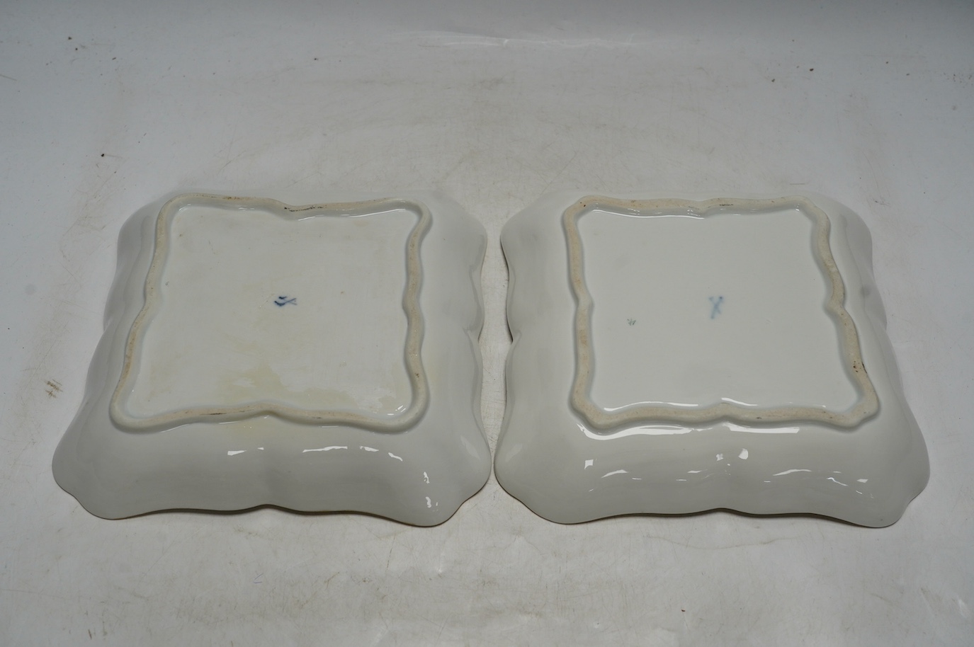 A pair of Meissen square shaped dishes, painted with scattered floral sprigs. Condition - fair to good